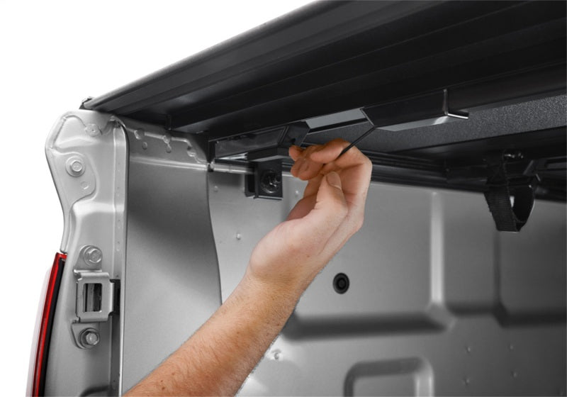 Person installing BAK 2022 Nissan Frontier 5ft Bed BAKFlip MX4 Matte Finish