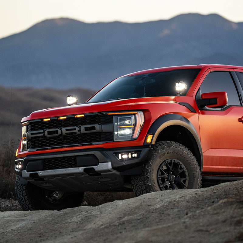 Baja Designs 21+ Ford Raptor / 22+ Bronco S2 SAE Pro Fog Pocket Light Kit on offroad truck in mountainous terrain.