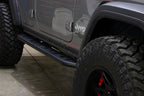 Fishbone Offroad 2018+ Jeep Wrangler JL Step Slider 4 Door on rugged tires and black finish.