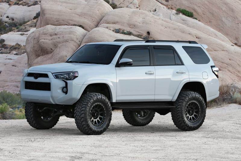 Fabtech 2015-21 Toyota 4Runner 4WD 6in Basic Sys w/Perf Shks with offroad tires and wheels on rocky terrain.