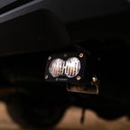 Baja Designs 2024+ Toyota Tacoma S2 Sport Reverse Kit w/ Plug and Play Harness mounted under a truck for offroad lighting.