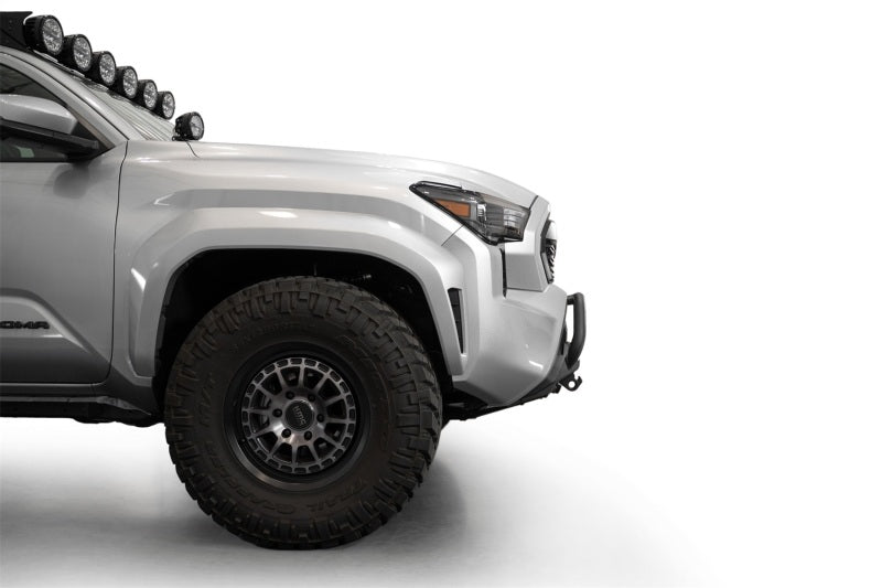 Addictive Desert Designs2024+ Toyota Tacoma Stealth Center Mount Winch Front Bumper w/ Top Hoop on a gray truck with offroad tires.