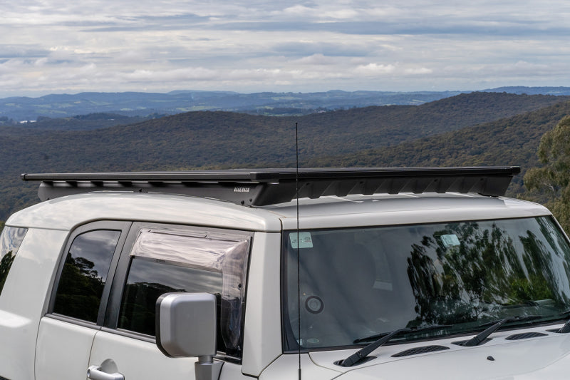 ARB Base Rack Deflector Base Rack 1770040 and Base Rack Mount Kit 17920020 on Toyota FJ Cruiser with scenic background.