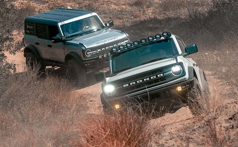 Two 2021 Ford Broncos off-roading with performance upgrades.