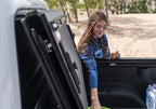 Woman accessing gear from BAK 2020 Jeep Gladiator 5ft Bed BAKFlip MX4