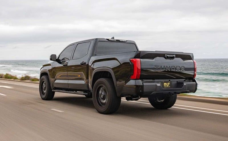 MagnaFlow 22+ Toyota Tundra Street Series 3in Dual Driver Side Rear Cat-Back Exhaust in action on a scenic road.