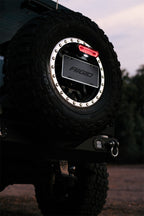 Rigid Industries Chase Tail Light Kit w/ Mounting Bracket - Red on off-road tire, enhancing Jeep exterior accessories.