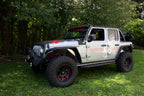 Fishbone Offroad 2018+ Jeep Wrangler JL Step Slider 4 Door on display outdoors with offroad tires and accessories.