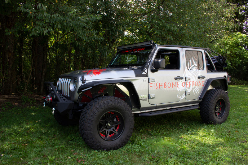 Fishbone Offroad 2018+ Jeep Wrangler JL Step Slider 4 Door on display outdoors with offroad tires and accessories.