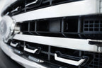 Addictive Desert Designs 2023+ Ford Super Duty Adaptive Cruise Control Relocation Bracket close-up on grille.