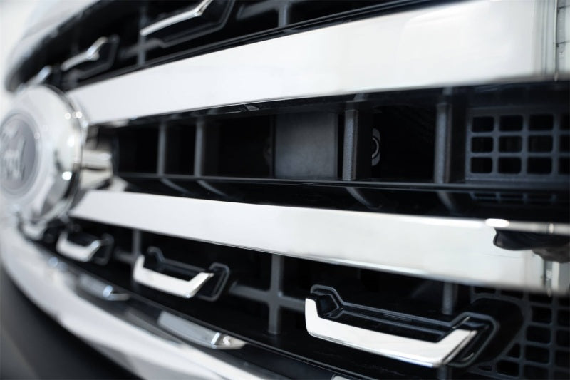 Addictive Desert Designs 2023+ Ford Super Duty Adaptive Cruise Control Relocation Bracket close-up on grille.