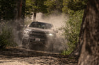 Fox Ford Raptor 3.0 Factory Series 12.3in External QAB P/B External Cooler Shock Set driving through off-road terrain.