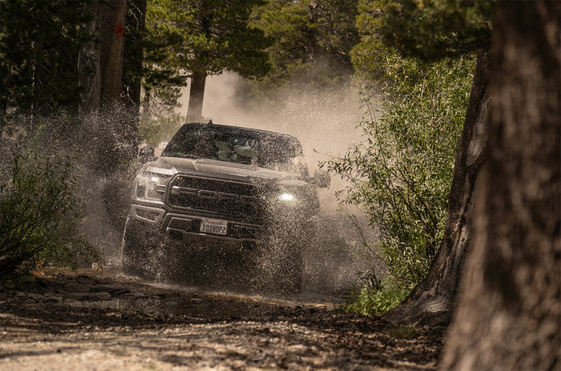 Fox Ford Raptor 3.0 Factory Series 12.3in External QAB P/B External Cooler Shock Set driving through off-road terrain.