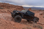Fox 18-Up Jeep JL / 20-Up Gladiator 2.0 Factory Series Gen2 2.0in. Trvl 10in Ext Front Bump Stop IFP on offroad terrain.
