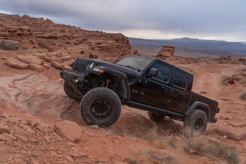 Fox 18-Up Jeep JL / 20-Up Gladiator 2.0 Factory Series Gen2 2.0in. Trvl 10in Ext Front Bump Stop IFP on offroad terrain.