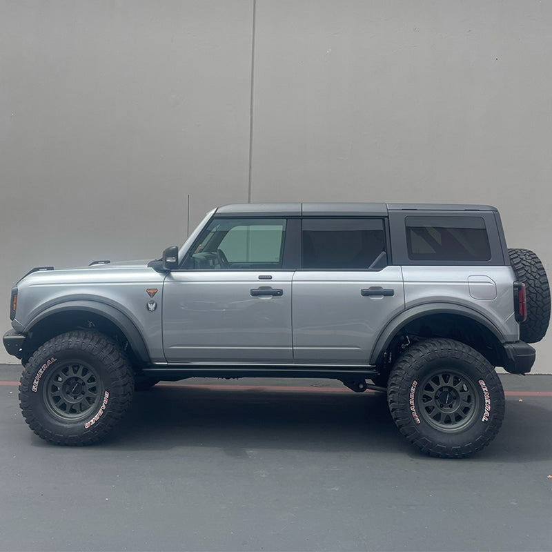 Camburg Ford Bronco 21-23 1.25in Performance Uniball Upper Arms (w/Covers) installed on a lifted truck with offroad tires.