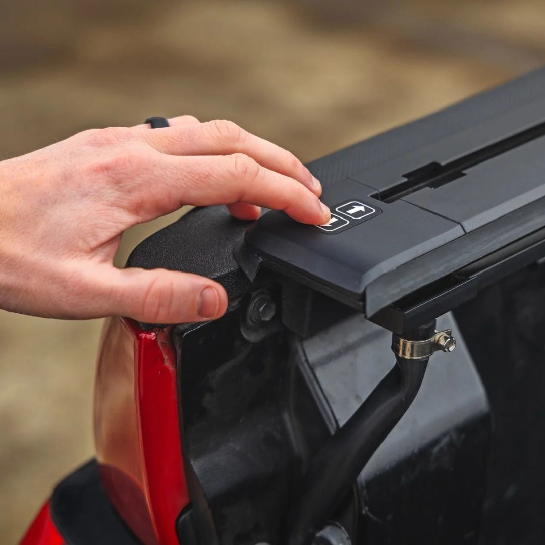 Hand operating a truck tailgate lock with offroad accessories