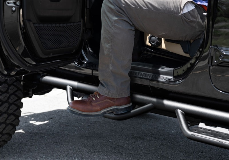 N-Fab RS Nerf Step 18-19 Jeep Wrangler JL 4DR - Full Length - Tex. Black with a person stepping on it.