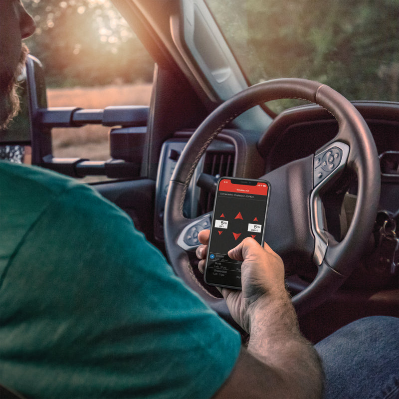 Person using Air Lift Wireless Air Control System w/ Wireless Phone App Control in truck.