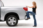 Woman stepping onto AMP Research 2007-2013 Toyota Tundra BedStep - Black for easy truck access.