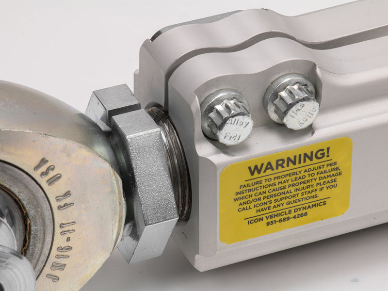 ICON 2007+ Toyota FJ / 2003+ Toyota 4Runner / 2008+ Toyota LC200 Billet Lower Trailing Arm Kit close-up with warning label