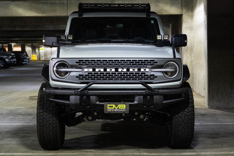 DV8 Offroad 21-22 Ford Bronco Factory Front Bumper Licence Relocation Bracket - Front in parking garage with offroad wheels.