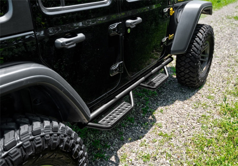 N-Fab RS Nerf Step 18-19 Jeep Wrangler JL 4DR - Full Length - Tex. Black side view with offroad tires and rugged terrain.
