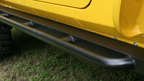 Body Armor 4x4 04-06 Jeep Wrangler Unlimited Rockcrawler Side Steps installed on yellow Jeep.
