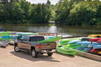 BAK 19-20 Dodge Ram (New Body Style w/o Ram Box) 5ft 7in Bed BAKFlip FiberMax with kayaks at the waterfront.