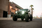 DV8 Offroad 18-22 Jeep Gladiator Wrangler LED Projector Headlights on modified Jeep in urban setting.