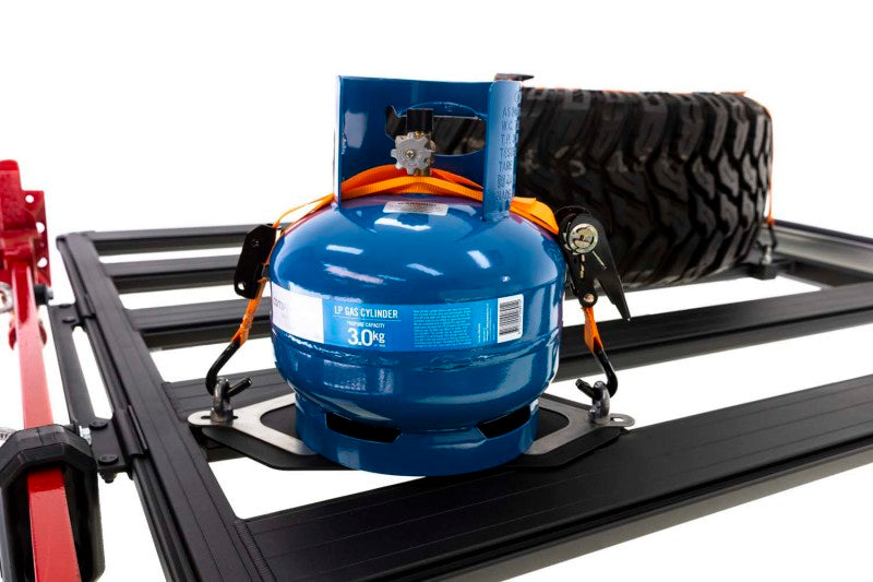ARB BASE Rack Gas Bottle Holder securely holding a blue gas canister on offroad truck accessories.