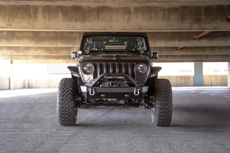 DV8 Offroad 07-23 Jeep Wrangler JK/JL & Gladiator JT FS-15 Series Front Bumper with offroad tires parked indoors