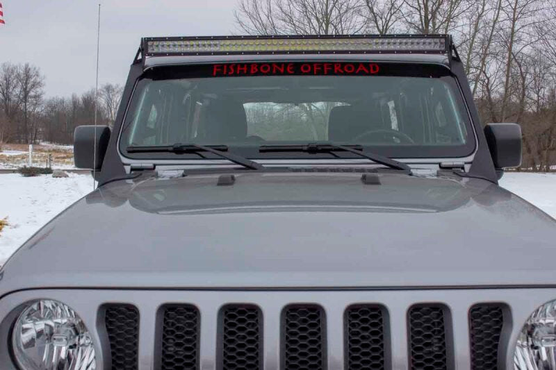 Fishbone Offroad 2018+ Jeep Wrangler JL Windshield Light Bracket mounted on a gray Jeep, showcasing offroad lighting.