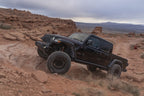 Fox 18-Up Jeep JL / 20-Up Gladiator 2.0 Factory Series Gen2 2.0in. Trvl 10in Ext Front Bump Stop IFP in offroad terrain