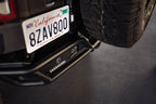DV8 Offroad 21-23 Ford Bronco Rear License Plate Relocation Bracket mounted on vehicle with spare tire.