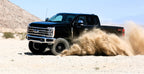 Fabtech 05-07 Ford F250/350 4WD 6in Coil Spring Kit - Black in action off-roading.