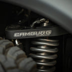 Camburg Ford Bronco 21-23 KINETIK V2 Performance Billet Uniball Upper Arms close-up with offroad wheels and suspension.