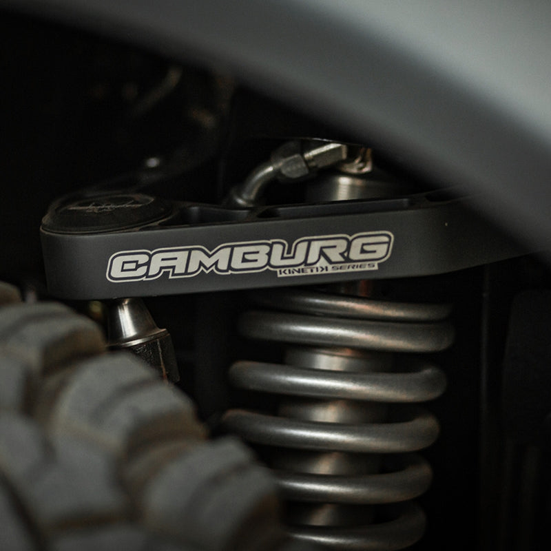 Camburg Ford Bronco 21-23 KINETIK V2 Performance Billet Uniball Upper Arms close-up with offroad wheels and suspension.