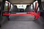 Fishbone Offroad 84-01 Jeep Cherokee XJ Rear Seat Hi-Lift Jack Mount installed in a red Jeep interior.