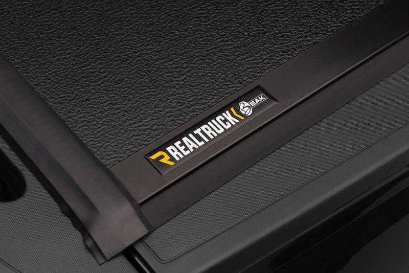BAK 14-18 Chevy Silverado 1500 / 15-20 2500/3500 8ft Bed BAKFlip G2 hard folding truck bed cover with RealTruck logo.