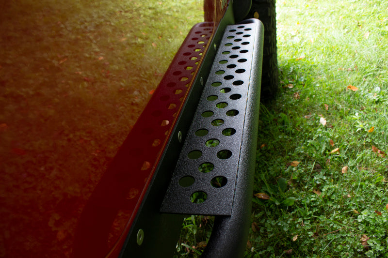 Fishbone Offroad 97-06 Jeep Wrangler TJ Steel Rock Slider - Black Textured Powdercoat on grass