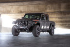 DV8 Offroad 07-23 Jeep Wrangler JK/JL & Gladiator JT FS-1 Series Stubby Front Bumper on a Jeep Gladiator in a modern setting.