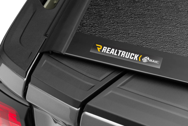 BAK 88-13 Chevy Silverado & C/K 1500 / 88-14 Chevy Silverado 2500/3500 HD 6ft 6in Bed BAKFlip F1 close-up with REALTRUCK logo.