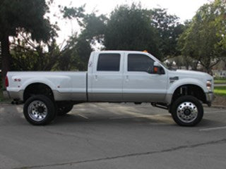 Lifted white truck showcasing offroad parts and accessories.