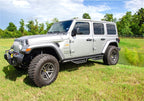 N-Fab Podium LG 2019 Jeep Wrangler JT 4DR Truck - Full Length - Tex. Black - 3in. on lush green field.