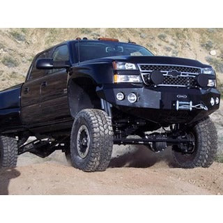 Black off-road truck with performance parts and lift kit on rugged terrain.