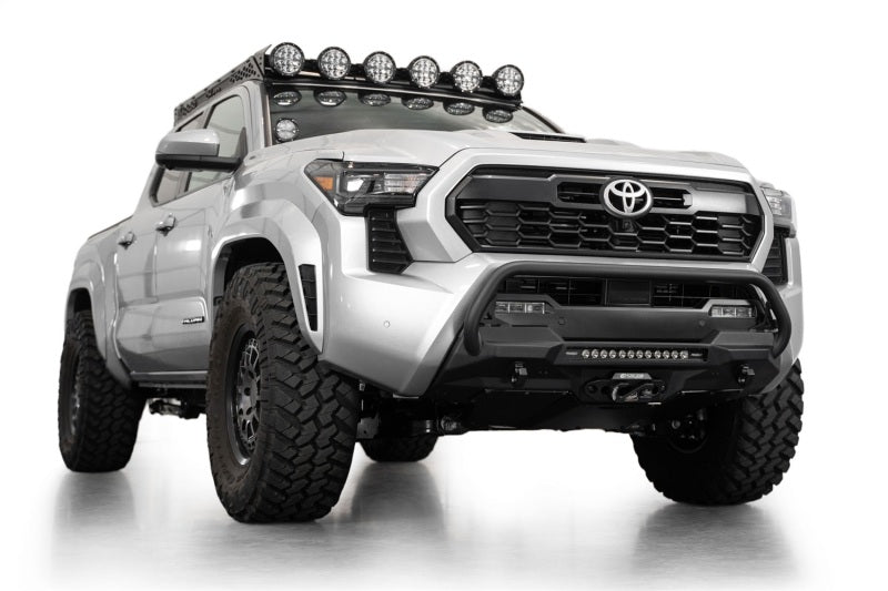 Addictive Desert Designs2024+ Toyota Tacoma Stealth Center Mount Winch Front Bumper w/ Top Hoop on lifted truck with offroad tires.