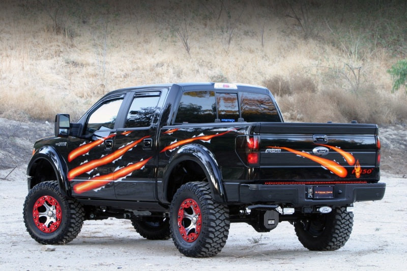 AMP Research 2009-2014 Ford F150 All Cabs PowerStep - Black truck with stylized graphics and offroad tires.