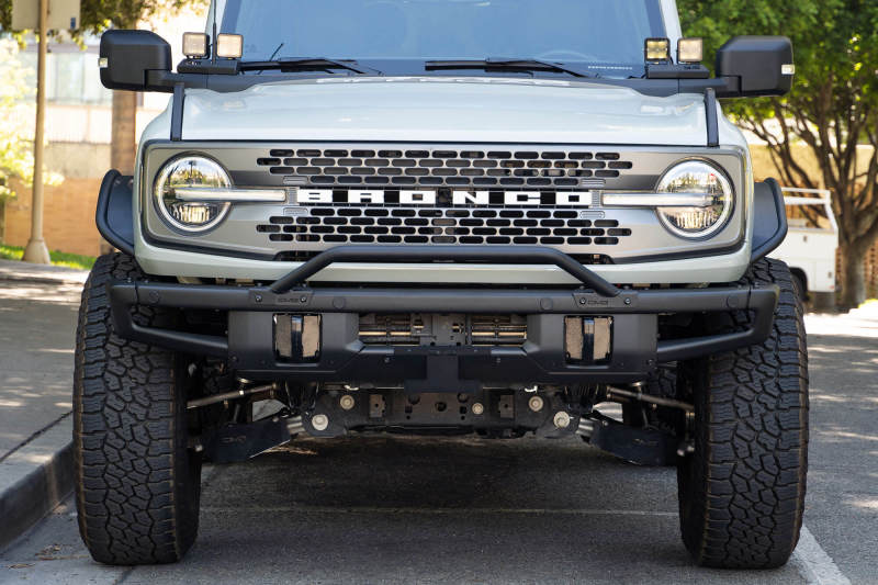 DV8 Offroad 21-22 Ford Bronco Factory Front Bumper Licence Relocation Bracket - Front on offroad truck with wheels