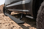 AMP Research 20-23 Jeep Gladiator (Launch/Overlnd/Rubicon/Sport/Sport S) PowerStep Xtreme - Black close-up in off-road terrain.
